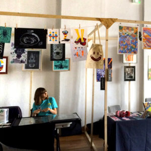Aperçu du stand Superfruit au Festival de micro édition "L'Enfer" à Nancy, structure en bois et affiches sérigraphiées