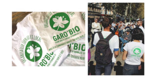 T-shirts sérigraphiés Garo'Bio pliés en tas et gens les portants pendant un concert